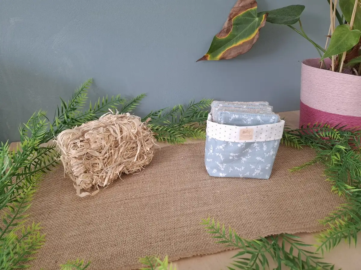 Panier et ses lingettes démaquillantes à fleurs sur fond bleu ciel